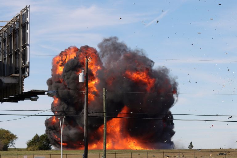 A historic military plane is engulfed in a ball of flames and black smoke as it crashes after colliding with another plane during an airshow at Dallas Executive Airport in Dallas, Texas.