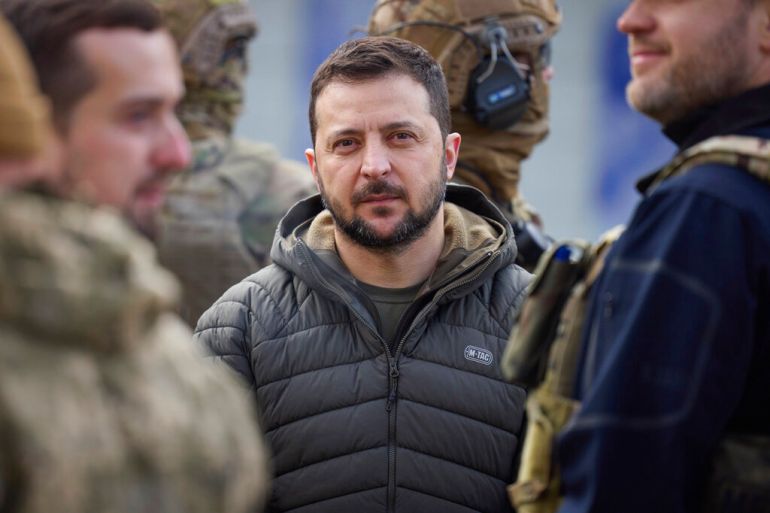 Volodymyr Zelenskyy seen looking at the camera and surrounded by military service members during his visit to Kherson, Ukraine on November 14, 2022.