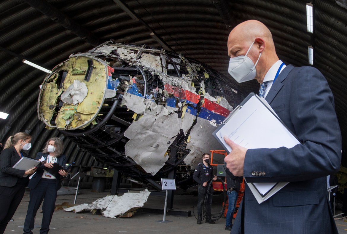 Presiding judge Hendrik Steenhuis, right, and other trial judges and lawyers view the reconstructed wreckage of Malaysia Airlines Flight MH17