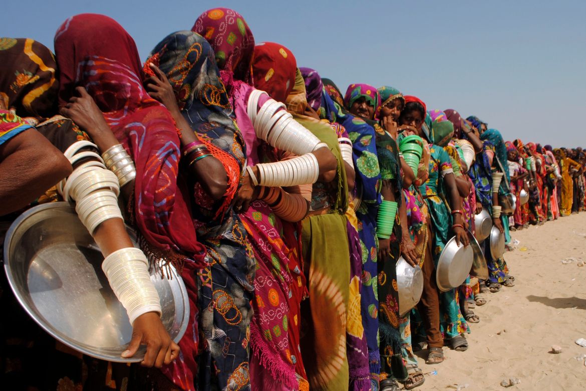 Women from flood-affected areas wait to get free food distributed by a charity, in Chachro, near Tharparkar, a district of southern Sindh province, Pakistan