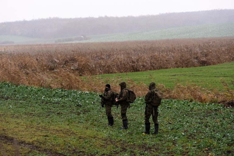 Polish soldiers search for missile wreckage in the field, near the place where a missile struck, in a farmland at the Polish village of Przewodow, near the border with Ukraine, Thursday, Nov. 17, 2022. (AP Photo/Vasilisa Stepanenko)