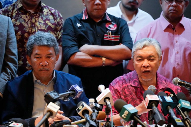Ahmad Zahid Hamidi speaking to the media after discussions with PH. He looks serious and is surrounded by other lawmakers from his party