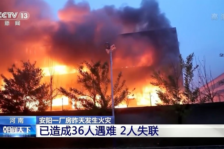 Flames and black smoke billow from the burning factory in footage taken from TV