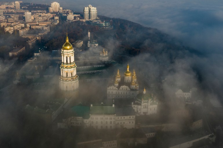 An aerial view of the Kyiv Pechersk Lavra with its golden domes breaking through the mist