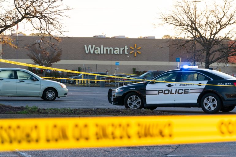 Crime scene tape and Chesapeake police cars gather outside a Walmart the morning of November 23, 2022