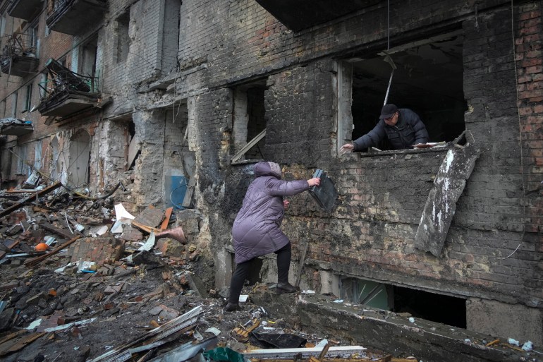 People gather their belongings from a damaged house after Russian shelling in the town of Vyshgorod outside Kyiv