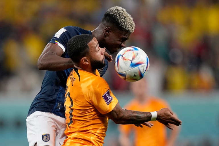 Ecuador's Felix Torres, rear, and Memphis Depay of the Netherlands challenge for the ball