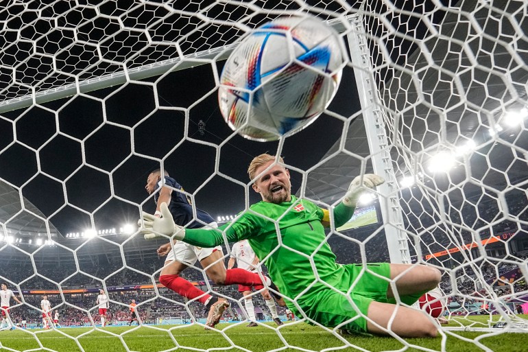 Kylian Mbappe of France scores his side's second goal past Danish goalkeeper Kasper Schmeichel during the World Cup Group D football match between France and Denmark, at Stadium 974 in Doha, Qatar, Saturday, Nov. 26, 2022. (AP Photo/Martin Meissner)