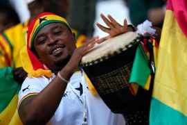 A Ghanaian fan plays a traditional drum