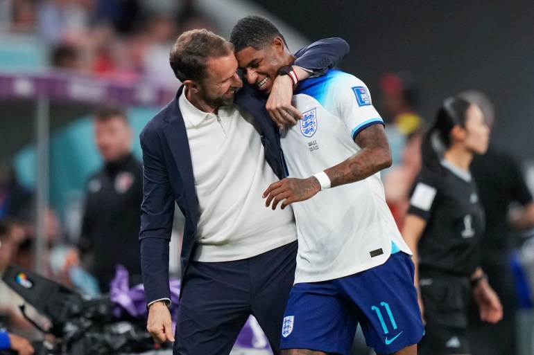 England's Marcus Rashford, right, is greeted by England's head coach Gareth Southgate as he leaves the pitch
