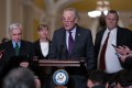 Chuck Schumer speaks at a podium in the Capitol, surrounded by his fellow lawmakers