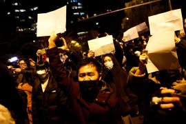 People hold a vigil against COVID-19 restrictions in Beijing on November 27, 2022 [Thomas Peter/Reuters]