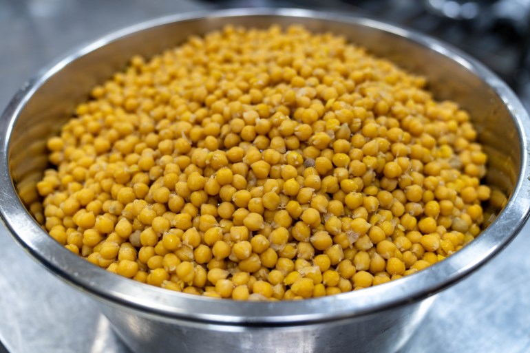 A stainless steel bowl of boiled chickpeas