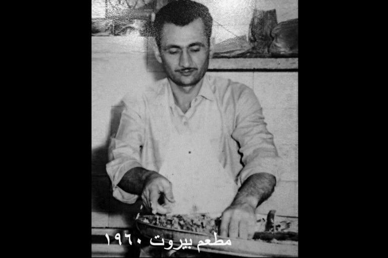An old photo of Abu Jihad preparing food on a big tray in 1960