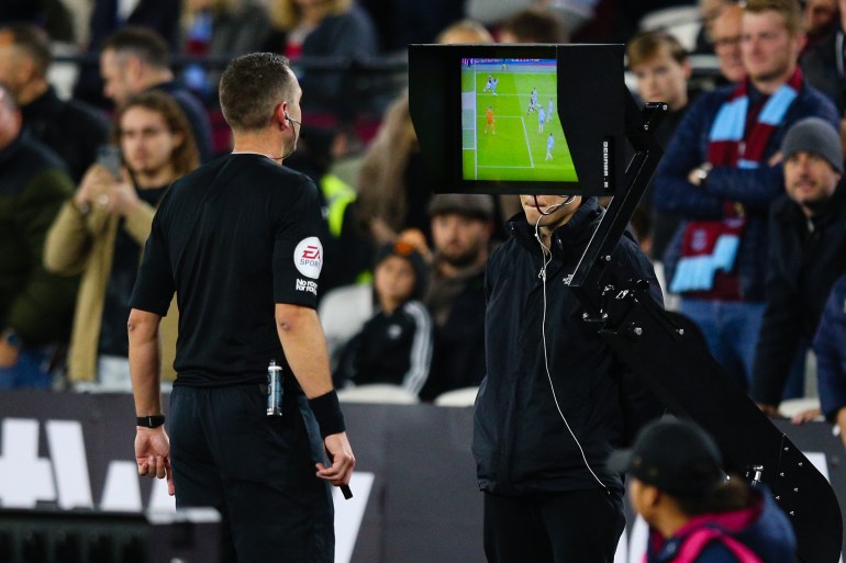 Referee David Coote checks VAR replays on the pitchside monitor before awarding West Ham United a penalty during the Premier League match between West Ham United and AFC Bournemouth at London Stadium on October 24, 2022 in London, United Kingdom.