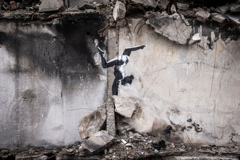 Graffiti of a woman in a leotard doing a handstand is seen on the wall of a destroyed building in Borodyanka on November 11, 2022 in Kyiv Region, Ukraine.