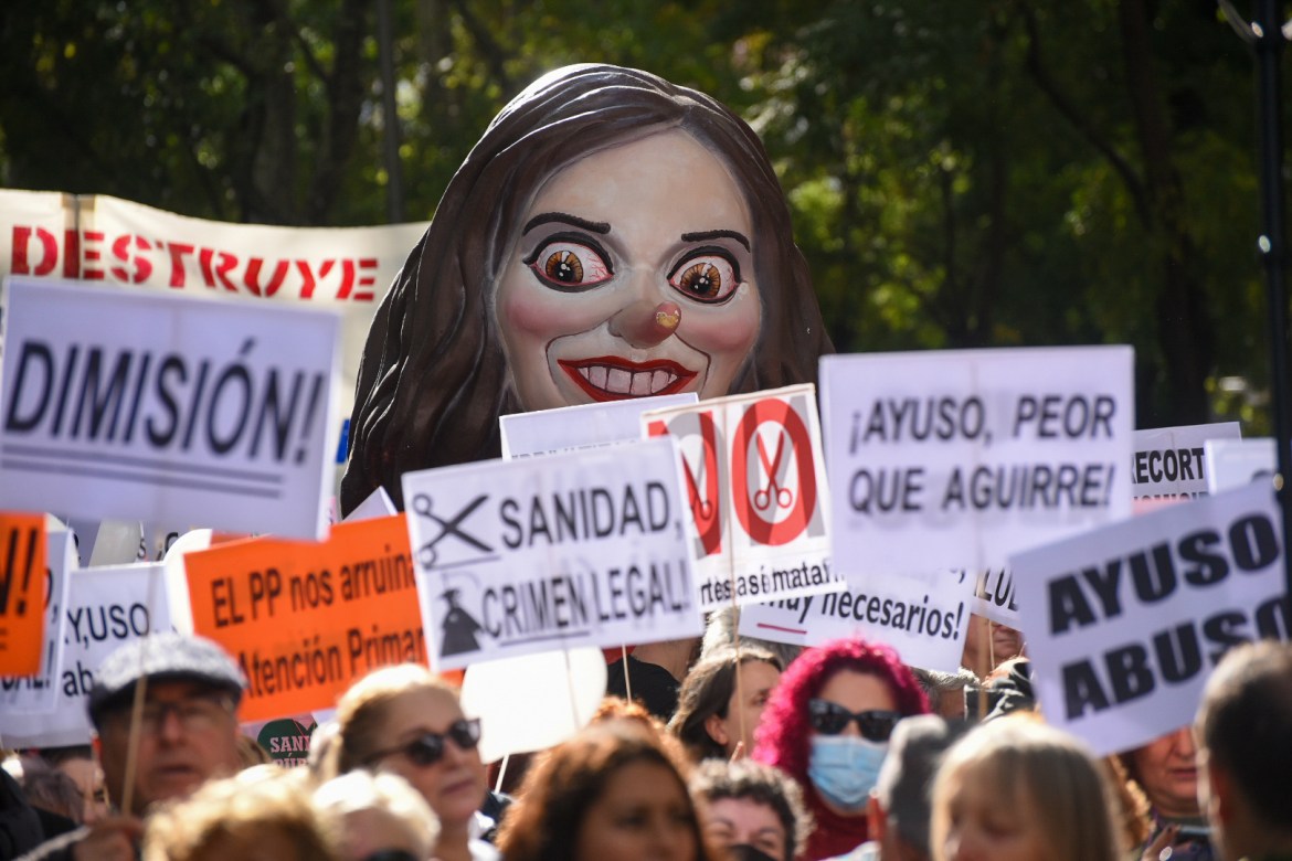Ayuso cartoon over the heads of thousands of protestors in Madrid.