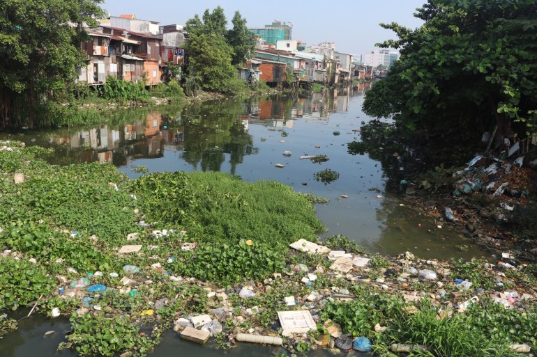 A view of a Ho Chi Minh City canal with plastic boxes, bottles and other bits of rubbish caught in the water hyacinth