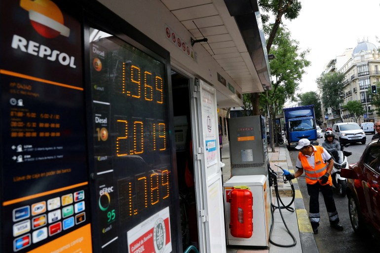 A photo of a worker prepares to pump gas into a car at a Repsol gas station in Madrid, Spain.
