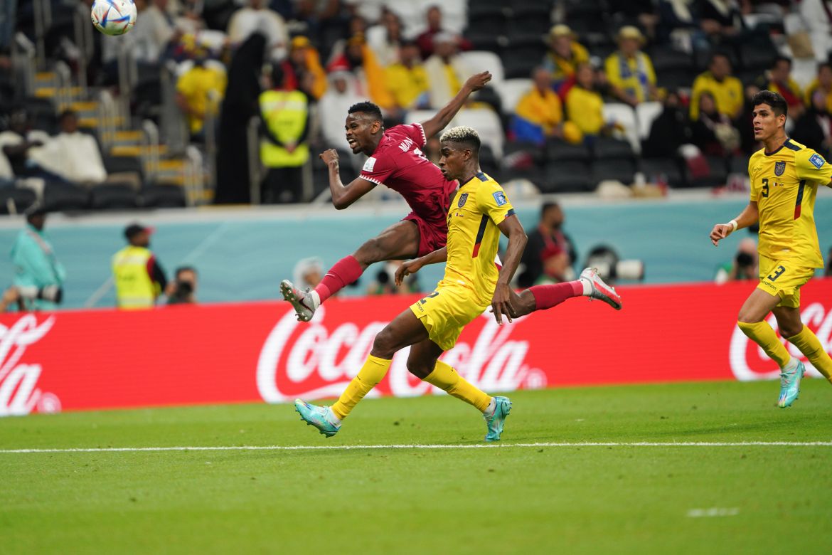 Qatari player drives past two Ecuadorian defenders