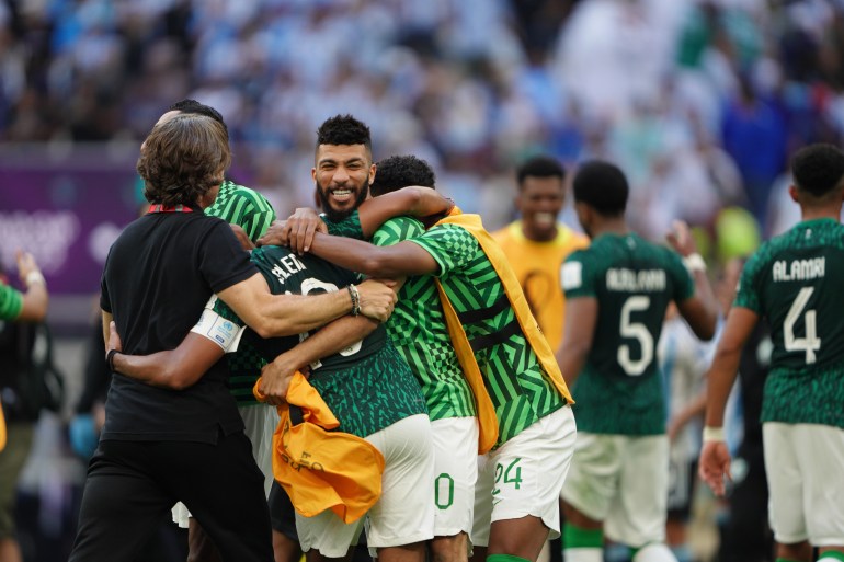 Saudi team hug in celebration after winning their match against Argentina.