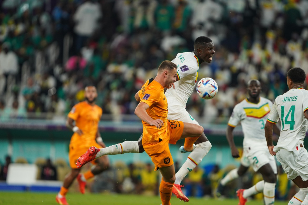 Dutch and Senegalese players challenge for possession of the ball.