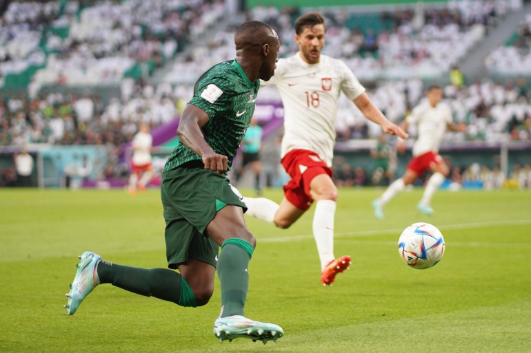 Players from Poland and Saudi Arabia compete for the ball.