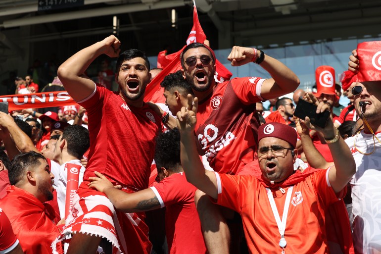 Tunisian fans cheering at Al Janoub Stadium.