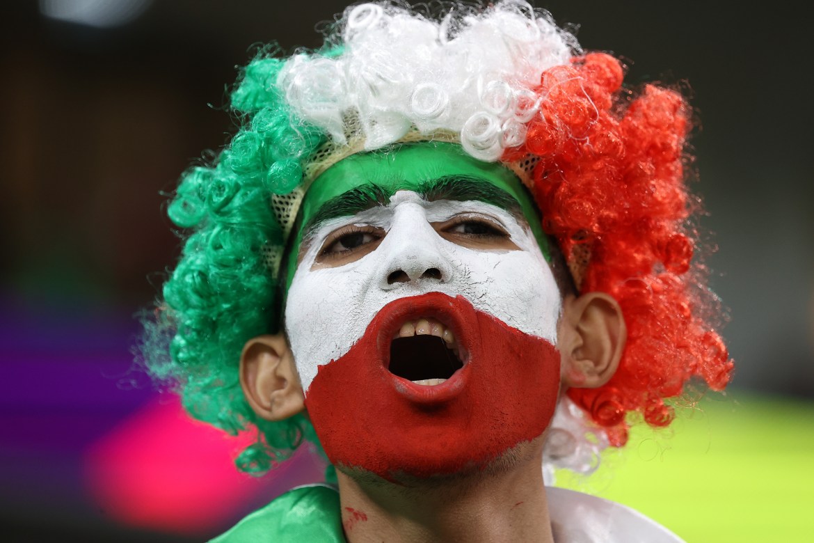 Iranian fan in the stands cheering for their side.