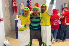 Football fans pose with a customised Brazilian version of a ghutra and other accessories at a Qatari sports shop