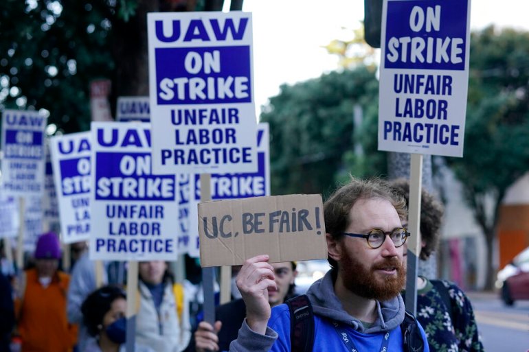 Academic workers hold strike signs in a picket line