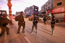 Israeli security forces aim their guns as they deploy in the occupied West Bank settlement of Huwara, following an incident during which a Palestinian man was shot dead by Israeli police, on December 2, 2022 [Jaafar Ashtiyeh/AFP]