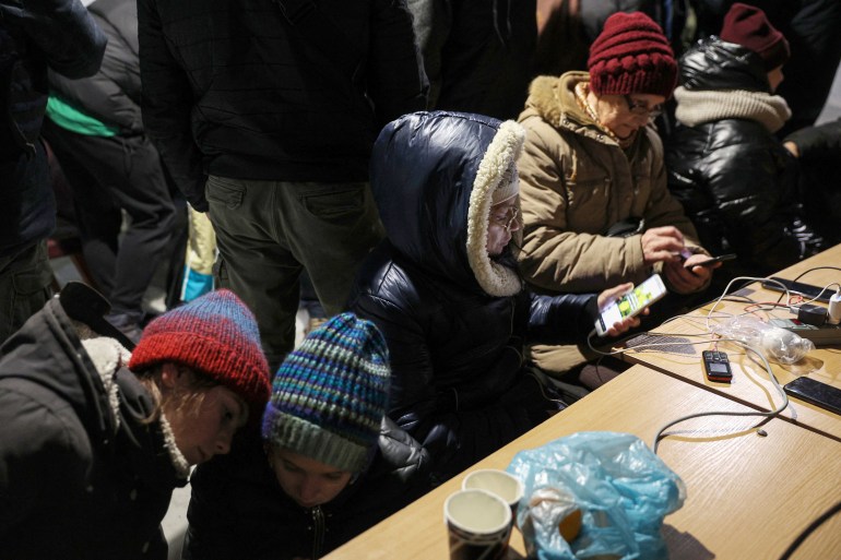 Ukrainians in thick coats and hats charge their phones and get warm inside a special mobile heated centre to help people get through power blackouts.