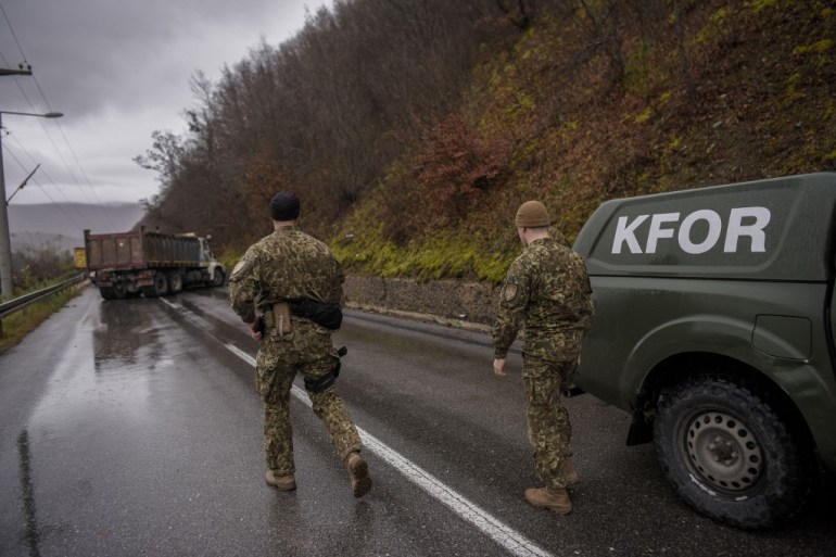 NATO soldiers serving in the peacekeeping mission in Kosovo (KFOR) inspect a road barricade set up by ethnic Serbs near the town of Zubin Potok