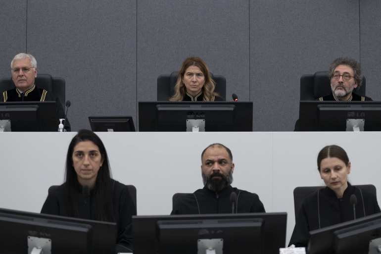 Presiding judge Mappie Veldt-Foglia (Top row, C), prepares to read the verdict in the case of Salih Mustafa, a former Commander of a BIA guerilla unit, which operated within the Llap Operational Zone of the Kosovo Liberation Army (KLA), waits in the Kosovo Specialist Chambers court for the judges to read the verdict, in The Hague, on December 16, 2022. - A special Kosovo court in The Hague convicted former rebel commander Salih Mustafa on December 16, 2022 of murder and torture and jailed him for 26 years in its first war crimes verdict. (Photo by Peter Dejong / POOL / AFP) / Netherlands OUT