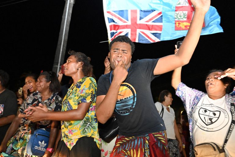 Supporters of the People's Alliance Party celebrate after securing the support of the Social Democratic Liberal Party to form a new coalition government in Suva on December 20, 2022 [Saeed Khan/AFP]