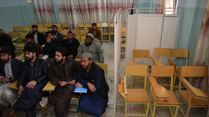 Male university Students attend class bifurcated by a curtain separating males and females at a university in Kandahar Province