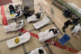 Covid-19 coronavirus patients lie on hospital beds in the lobby of the Chongqing No. 5 People's Hospital in China's southwestern city of Chongqing on December 23, 2022. (Photo by Noel CELIS / AFP)