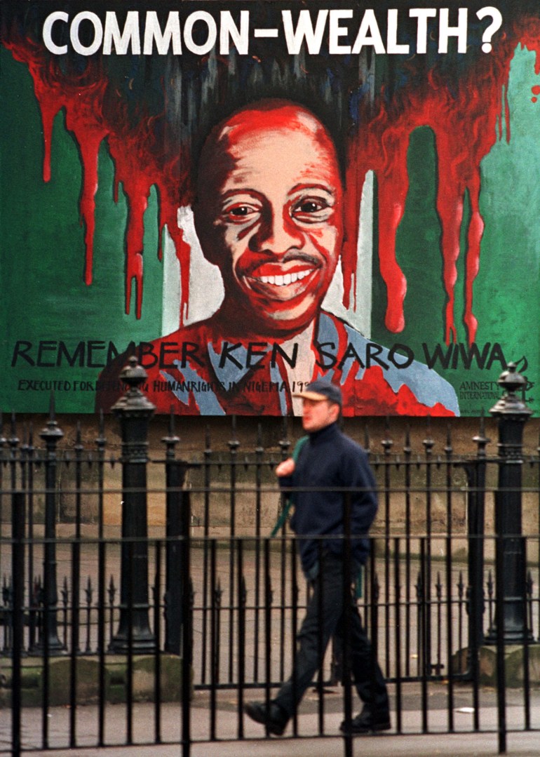 A man walks past an Amnesty International portrait of Nigerian author Ken Saro Wiwa