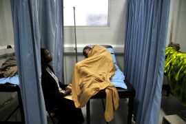 An attendant cares for a patient infected with HIV/AIDS in a ward in Uganda's Infectious Disease Institute