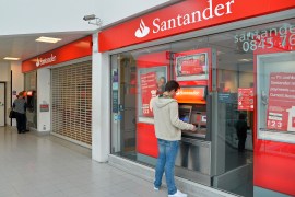 Customers use ATM machines at the Surrey Quays branch of Santander bank in south London [File: Toby Melville/Reuters]