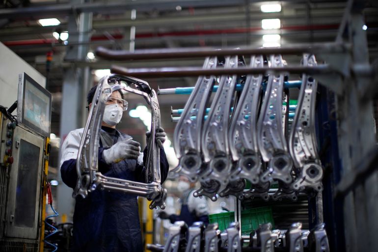 An employee wearing a face mask works on a car seat assembly line at Yanfeng Adient factory in Shanghai, China.