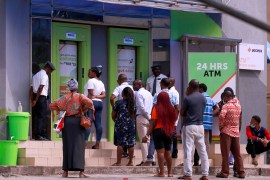 People wait near an ATM in Nigeria