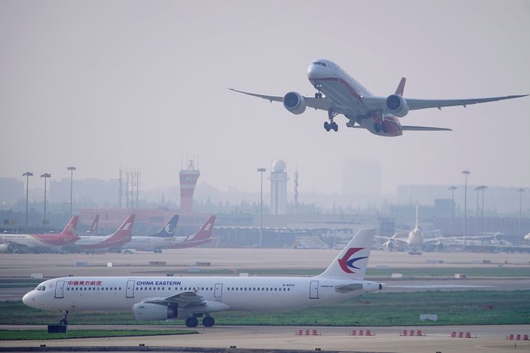 A China Eastern Airlines aircraft on the tarmac as a Shanghai Airlines aircraft takes off at the Hongqiao International Airport in Shanghai, China.