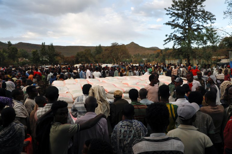 People stand in line to receive food donations, at the Tsehaye primary school, which was turned into a temporary shelter for people displaced by conflict, in the town of Shire, Tigray region, Ethiopia, March 15, 2021. Picture taken March 15, 2021. REUTERS/Baz Ratner