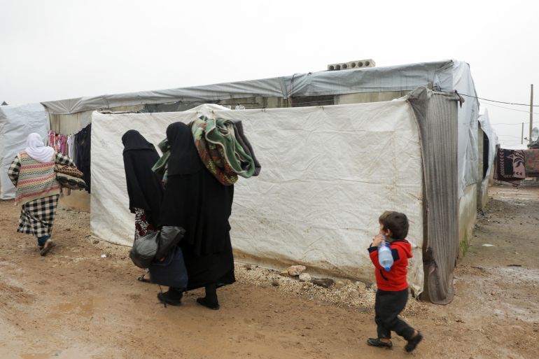 Internally displaced Syrians walk together near tents at a camp in Azaz, Syria March 1, 2022. Picture taken March 1, 2022. REUTERS/Mahmoud Hassano