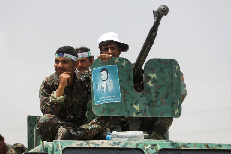Houthi police troopers sit atop an armored personnel carrier securing a rally held to mark the Ghadeer day
