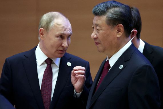 Russian President Vladimir Putin speaks with Chinese President Xi Jinping