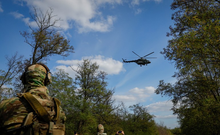 Um helicóptero do exército russo sobrevoa, enquanto voluntários de um batalhão recém-formado participam de um treinamento fora da cidade de Melitopol, Ucrânia controlada pela Rússia, 13 de outubro de 2022. REUTERS/Alexander Ermochenko