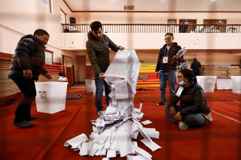 An official from Nepal's election commission pours the ballot papers from the box,